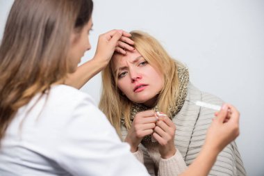 Ateşi onu rahatsız ediyor. Doktor, sağlıksız kadını evde ziyaret etti. Tıp doktoru hastayı muayene ediyor. Birinci basamak doktoru hasta kadına teşhis koyarak. Hasta bakımı ve sağlık