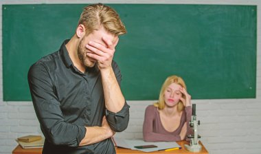 He left a lesson unlearned. University or college student covering face. Male student with examiner at examination. Handsome man standing in classroom with teacher. High school student saying lesson clipart