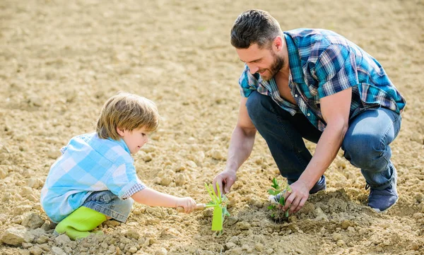 rich natural soil. Eco farm. new life. soils and fertilizers. small boy child help father in farming. father and son planting flowers in ground. happy earth day. Family tree. earth day. Successful