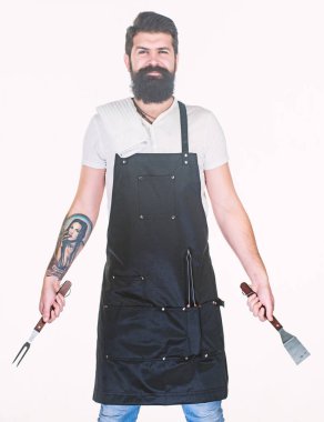 Profesyonel Barbekü. Barbekü çatalı ve spatula elinde olan sakallı adam. Cook Portatif Barbekü yemek araçları kullanarak ızgara. Paslanmaz çelik Barbekü yiyecek hazırlama araçları tutarak hipster