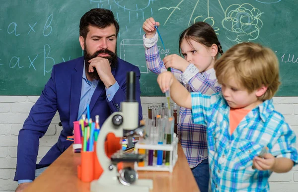 microscope optical instrument at science classroom. back to school. happy children teacher. learn using microscope at school lesson. Early development of children. Friendly children in lab.