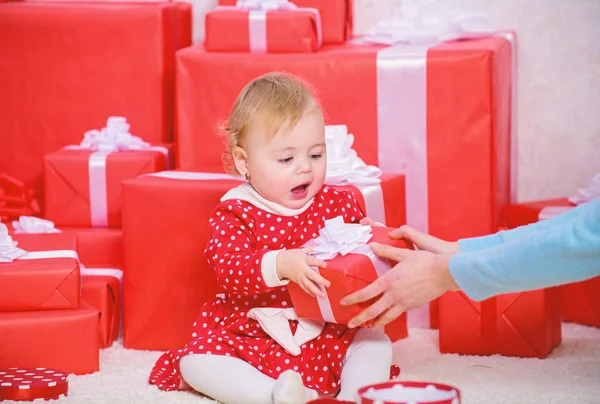 Отпразднуй первое Рождество. Делиться радостью первого Рождества с семьей. Первое рождество ребенка раз в жизни. Маленькая девочка играет рядом с кучей подарочных коробок. Подарки для первого ребенка — стоковое фото