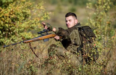 Hunter tüfeği tutuyor. Avlanma izni. Sakallı ciddi avcı boş zamanlarını avlayarak geçiriyor. Profesyoneller için av ekipmanları. Avlanmak acımasız erkeksi bir hobidir. Adam kamuflaj giysiler doğa arka plan giymek