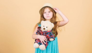 Oyuncak ayıya aşık. Mutlu bir çocukluk. Şefkat bağları. Küçük kız oyuncak ayıcığın bej arka planına dikkatlice sarıldı. Gelmiş geçmiş en tatlı. Küçük kız hasır şapka, oyuncak ayı pelüş oyuncak.