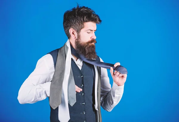 Classic style. How to match necktie with shirt and suit. Man bearded hipster hold few neckties on blue background. Guy with beard choosing necktie. Gentlemens guide. How to choose right tie