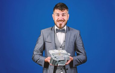 Kolay nakit krediler. İşadamı nakit para var. Nakit kolay ve hızlı bir şekilde olsun. Nakit işlem iş. Adam mutlu kazanan zengin doları banknot yığını mavi arka plan tutun. Piyango kavramı kazanmak