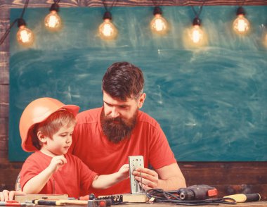 Evlat, Çocuk koruyucu kask meşgul el ile baba ile onarım yapar. Sınıfta, arka plan kara tahta araçlarını kullanmak için küçük oğlu öğretim sakallı baba. Küçük Yardımcısı kavramı