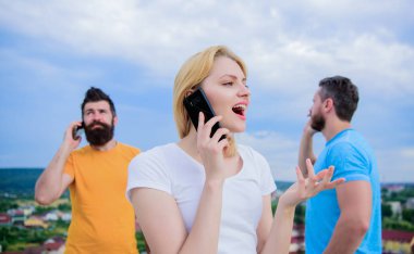 Birbirleri ile bağlantıda kalmak. Akıllı telefonları açık havada modern insanlar. Cep telefonu kullanıcıları. İnsanlar ve teknoloji. Mobil iletişim teknolojisini kullanarak. Cep telefonlarıyla konuşan bir grup arkadaş