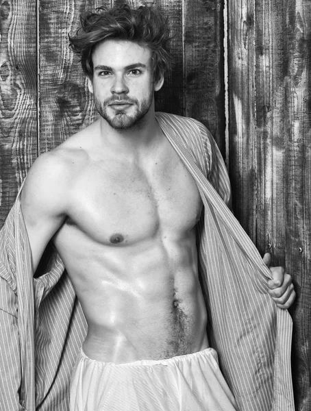 Bachelor sexy body chest and belly. Guy shimmering skin undressing bathrobe. Sexy attractive macho tousled hair on wooden background. Man athlete with fit torso. Sportsman show six pack sexy torso — Stock Photo, Image