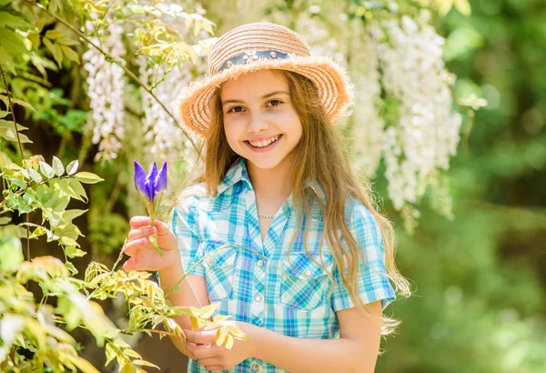 Kid hold flowers bouquet. Girl cute adorable teen dressed country rustic style checkered shirt nature background. Summer garden flower. Fresh flowers. Collecting flowers in field. Summer is here