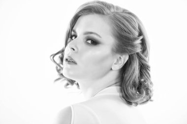 Beyaz arka planda makyajlı kendine güvenen bir kadın. Zarif makyaj konsepti. Retro ve antika. Mükemmel sağlıklı ciltli ve güzel makyajlı bir kız. Eski moda saç stili ve makyajı yakın çekim.