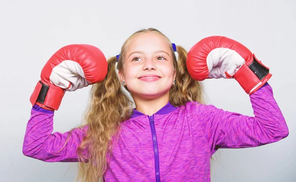 Liderlik için yetiştirildim. Güçlü çocuk boksu. Spor ve sağlık konsepti. Kadınlar için boks sporu. Spor yetiştirme. Başarılı bir lider olma yeteneği. Beyaz arka planda kırmızı eldivenli şirin bir kız.