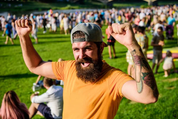 Open air concert. Fan zone. Music festival. Entertainment concept. Visit summer festival. Summer fest. Hipster in cap happy celebrate event fest or festival. Man bearded hipster in front of crowd