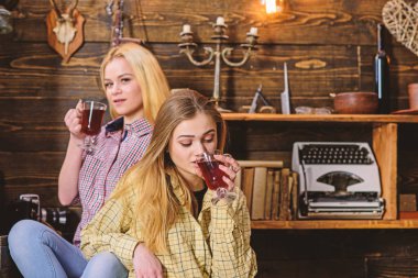 Kız arkadaşıyla beraber mulled şarap paylaşımı, rahatlatıcı. Rahatlatıcı ve mulled şarap içme kızlar. Tatil ve tatil kavramı. Arkadaşlar rahat kıyafetler içinde sıcak atmosferi, ahşap iç tadını çıkarın.