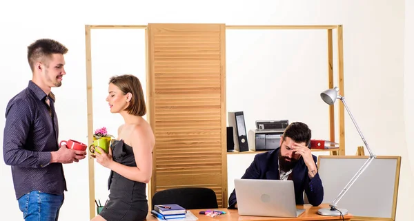 Employee break. Business partners enjoying conversation in lunch break while colleague working in background. Two coworkers having tea or coffee break. Young managers talking during work break