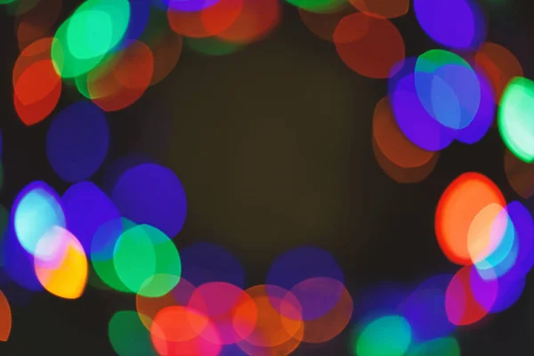 Defocused light of colorful garland. Festive backdrop with colorful lights. Bright and festive atmosphere of coming holiday. Abstract colorful bokeh background. Christmas decorations concept