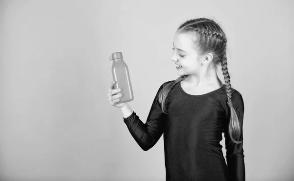 Kid roztomilá dívka gymnastka sportovní trikot drží láhev na pití. Vodní bilance a tvrdé tělocvik. Pít více vody. Udržujte láhev vody s sebou. Uhasit žízeň. Dítě cítí žízeň po sportovního tréninku — Stock fotografie