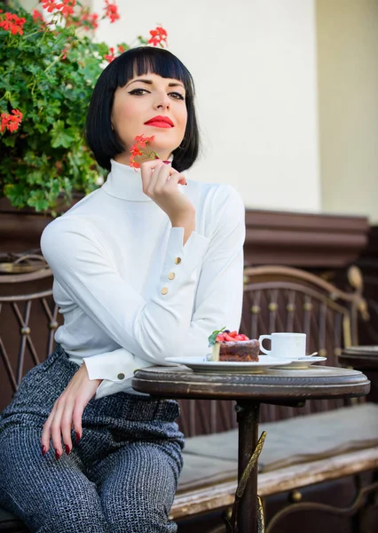 Женщина привлекательная элегантная брюнетка есть изысканный торт кафе терраса фоне. Изысканная концепция. Приятное время и отдых. Вкусный торт для гурманов. Побалуй себя. Кафе-релакс с тортом — стоковое фото