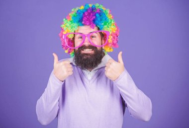 Parti eğlenceli. Deli olmanın tadını çıkarın. Kendinizi ifade çekinmeyin. Eğleniyor. Tatil eğlenceli ve karnaval kavramı. Adam giyim renkli peruğu ve menekşe arka plan üzerinde komik gözlük sakallı. Palyaço ve sirk