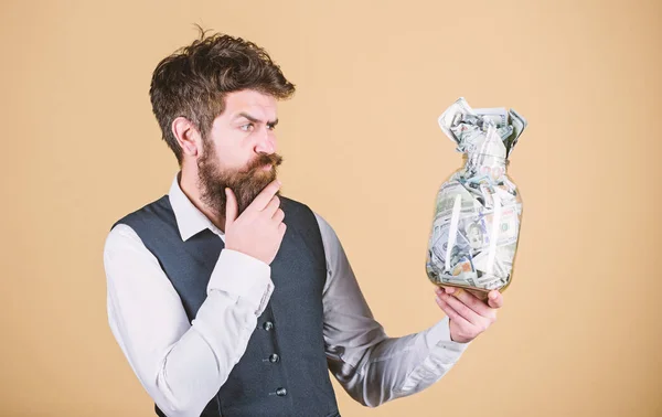 Financial success. Businessman with his dollar savings. Richness and wellbeing. Security and cash money savings. Banking concept. Man bearded guy hold jar full of cash savings. Establish your budget