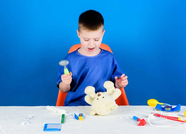 Medical procedures for teddy bear. Boy cute child future doctor career. Hospital worker. Health care. Kid little doctor busy sit table with medical tools. Medical examination. Medicine concept