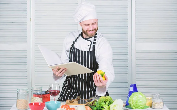 Boek familierecepten. Volgens het recept. Een man met een baard kookte eten. Hij heeft recepten gelezen. Culinaire kunst concept. De mens leert recept. Verbeter de kookvaardigheid. Ultieme kookgids voor beginners — Stockfoto