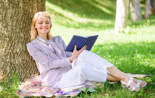 Business lady find minute to read book improve her knowledge. Self improvement and education concept. Female self improvement. Girl lean on tree while relax in park sit grass. Self improvement book Stock Picture