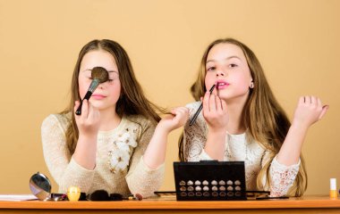 Kozmetik uzmanları. Yüz kozmetik giyen sevimli güzellik modelleri. Küçük kızlar makyaj fırçaları ile dekoratif kozmetik uygulayarak. Küçük çocuklar renkli kozmetik ile yüzleri boyama