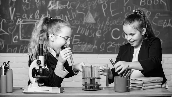 Concept d'expérience pédagogique. Microscope et éprouvettes sur table. Soyez prudent en effectuant une réaction chimique. Connaissances de base en chimie. Les filles étudient la chimie. Rendre l'étude de la chimie intéressante — Photo