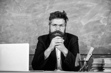 Konsantre öğretmen Olgun öğretmen dikkatle dinlerken sakallı. Ayrıntılara dikkat. Öğretmen formal Giyim tablo sınıf kara tahta arka plan otur. Öğretmen dinleme cevap veya rapor