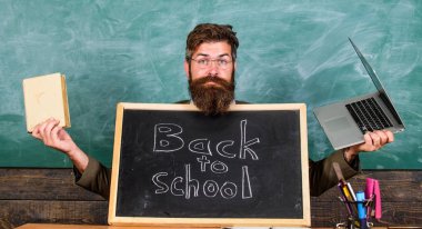 Öğretmen yeni öğrencilerin eğitim kurumuna girmesini memnuniyetle karşılıyor. Bize gel. Kayıtları artırmak için özel okul reklamları. Öğretmen veya okul müdürü okula geri tahta yazıt ile ağırlıyor