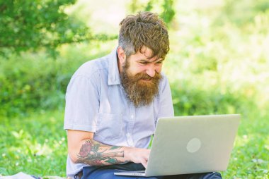 Blogcu doğadan ilham alıyor. Laptoplu sakallı bir adam çayır doğasında oturuyor. İlham veren doğa ortamı arayan bir yazar. Blog yazma ilhamı. İlham arıyorum.