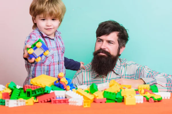 Nothing but family. father and son play game. small boy with dad playing together. child development. happy family leisure. building home with colorful constructor. family weekend. funny weekend