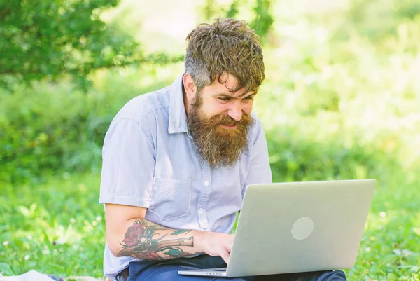 Blogcu doğadan ilham alıyor. Laptoplu sakallı bir adam çayır doğasında oturuyor. İlham veren doğa ortamı arayan bir yazar. Blog yazma ilhamı. İlham arıyorum.