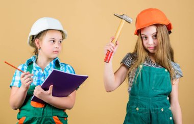 Kasklı çekiçli küçük çocuklar. İşçi bayramı. 1 mayıs. mutlu çocuklar. Gelecekteki kariyeri. Foreman müfettişi. Onarım. küçük kızlar atölyede birlikte tamir. Onarım dükkanında zor bir günün ardından yorgun hissetmek