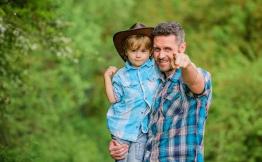 Şirin bir kovboy. Bahçede küçük bir yardımcı. Doğada yaşayan küçük bir çocuk ve baba. Macera ruhu. Babam gibi güçlüyüm. Güç, baba olmaktır. Çocuk eğleniyor kovboy baba. Köylü ailesi.
