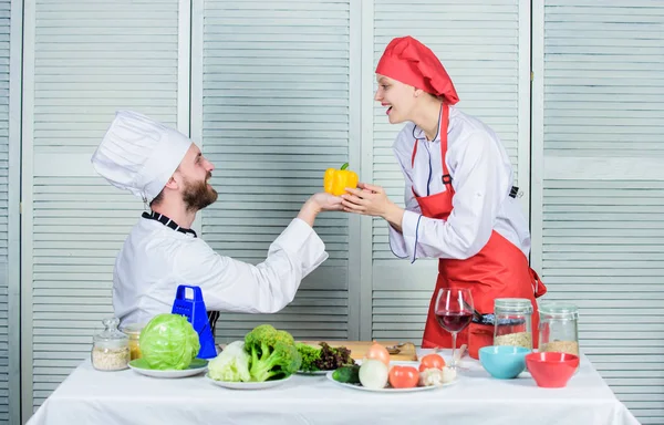vegetarian. cook uniform. Dieting vitamin. culinary cuisine. happy couple in love with healthy food. Family cooking in kitchen. man and woman chef in restaurant. propose a vitamin. vitamin in hand