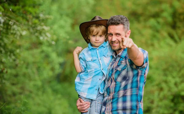 Şirin bir kovboy. Bahçede küçük bir yardımcı. Doğada yaşayan küçük bir çocuk ve baba. Macera ruhu. Babam gibi güçlüyüm. Güç, baba olmaktır. Çocuk eğleniyor kovboy baba. Köylü ailesi.