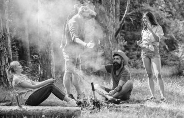 Yaz piknik katılın. Şirket sosis sopa üzerinde kavurma eğleniyor. Şenlik ateşi takılmak ve hazırlamak için toplantı arkadaşlar sosis aperatifler doğa arka plan kavrulmuş. Büyük piknik için toplama