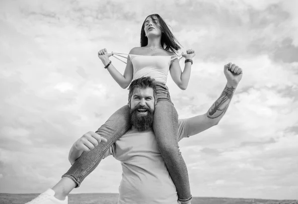 Feliz por estar apaixonada. Casal feliz no amor no céu nublado. Um homem barbudo a meter-se com a namorada só por diversão. Hipster dando a mulher sexy um passeio de piggyback. Amante casal feliz sorriso se divertindo — Fotografia de Stock