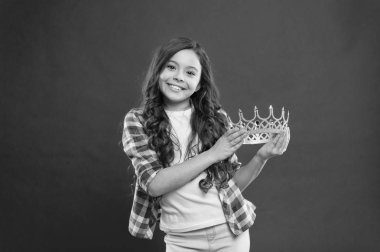 Benim en büyük hazine. Prenses altın taç sembolü tut evlat. Çocukluk kavramı. Her kız prenses olmak için hayal. Kız şirin bebek tutun taç stand kırmızı arka planı süre. Bayan küçük prenses