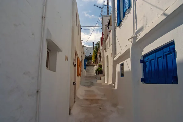 Street with steps in Mykonos, Greece. Whitewashed houses with blue wooden shutters architecture. Summer vacation on mediterranean island. Traveling and wanderlust. Famous tourist destination