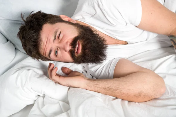 Lazy morning. Relax and sleep concept. Man bearded guy sleep on white sheets. Healthy sleep and wellbeing. Man bearded hipster sleepy in bed. Early morning hours. Insomnia and sleep problems