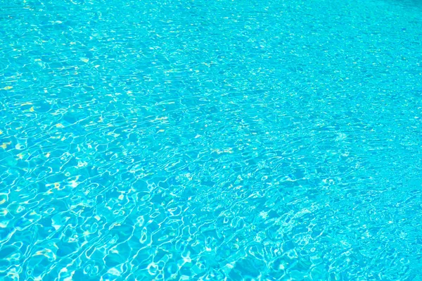 Εξοπλισμός πισίνας. Υφή θαλάσσιου υποβάθρου. Μικρά μπλε κύματα. Μαθήματα κολύμβησης. Διαφανές καθαρό νερό στην πισίνα. Επιφανειακή ροή νερού. Καθαριστικά πισίνας. Σπα και ευεξία. Πολυτελές θέρετρο — Φωτογραφία Αρχείου