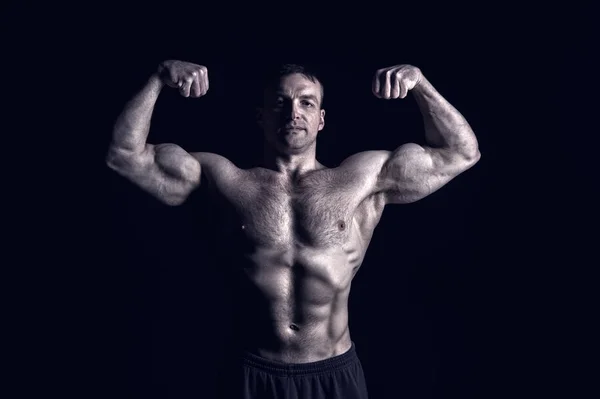 Kas vücut eğitim salonunda yakışıklı vücut geliştirmeci adamla — Stok fotoğraf