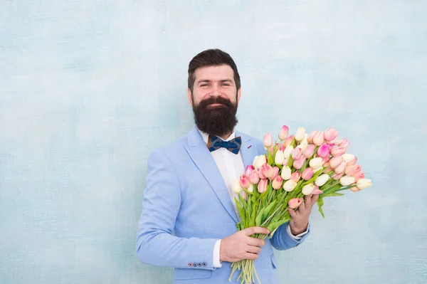 Homme barbu en nœud papillon avec des fleurs de tulipe. marié de mariée à la fête de mariage. bouquet de printemps. 8 de mars. rendez-vous amoureux avec des fleurs. Joyeux anniversaire. Journée des femmes. Homme d'affaires formel mature. Toujours jeune — Photo