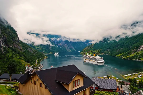 Destino de viaje, turismo. Nave en fiordo noruego en cielo nublado. Transatlántico en el puerto del pueblo. Destino de viaje, turismo. Aventura, descubrimiento, viaje . — Foto de Stock