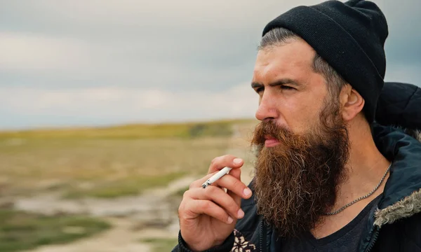 Man hipster eller kille med skägg och mustasch rökning cigarett — Stockfoto