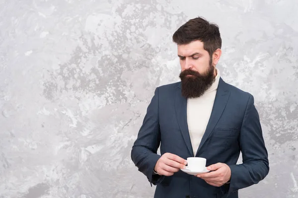 elegant man with beard drink coffee. Brutal bearded hipster in formal suit. Male fashion model. Mature businessman. Modern life. Tailor or fashion designer. Warming up with fresh coffee. More coffee