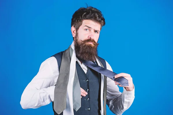 How to match necktie with shirt and suit. Man bearded hipster hold few neckties on blue background. Guy with beard choosing necktie. Gentlemens guide. How to choose right tie. Classic style